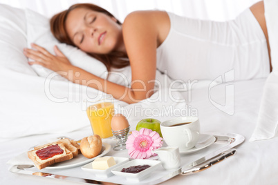 Young woman having breakfast in bed