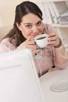 Happy businesswoman having coffee break at office