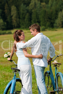 Romantic young couple with old bike in spring nature