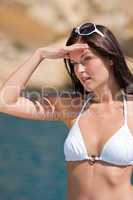 Beautiful woman in bikini sunbathing by the sea