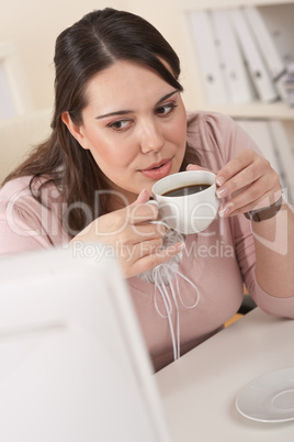 Young business woman enjoying coffee at modern office