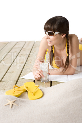 Beach - woman with cold drink in bikini sunbathing