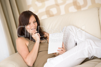 Young happy woman read book on sofa