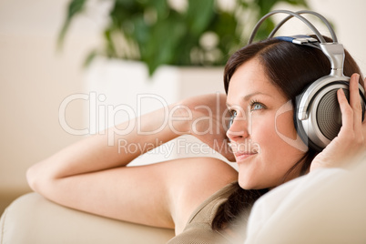 Smiling woman with headphones  listen to music in lounge