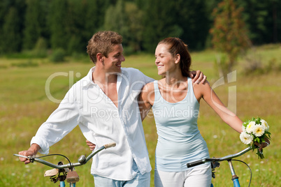 Romantic young couple with old bike in spring nature