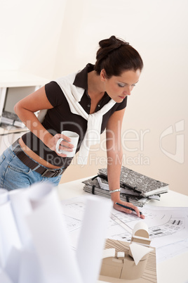 Young female architect working and drinking coffee