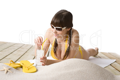 Beach - woman with cold drink in bikini sunbathing