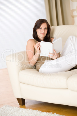 Young woman read book relaxing on sofa