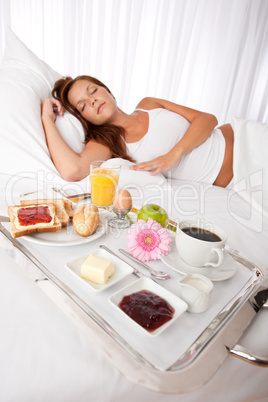 Young woman having breakfast in bed