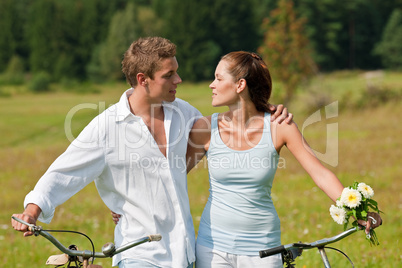 Romantic young couple with old bike in spring nature