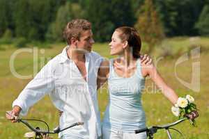 Romantic young couple with old bike in spring nature