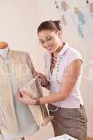 Female fashion designer taking measurement