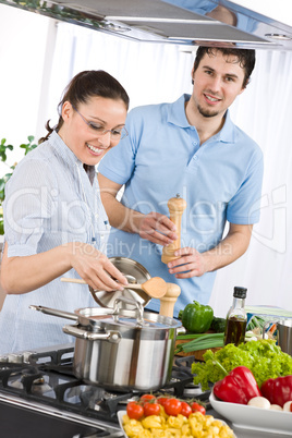 Happy couple cooking in modern kitchen