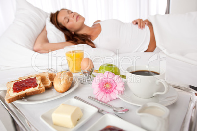 Young woman having breakfast in bed