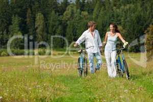 Romantic young couple with old bike in spring nature