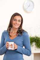 Happy young woman holding cup of coffee