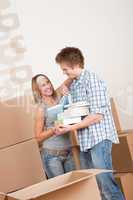 Moving house: Young couple with box in new home