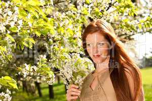 Young woman enjoying spring under blossom tree