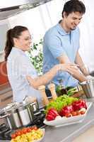 Smiling couple cooking in modern kitchen