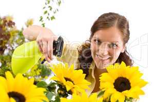 Gardening - woman sprinkling water on sunflower