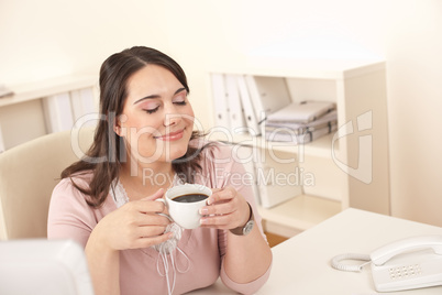 Young business woman enjoying coffee at modern office