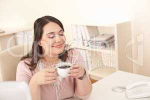 Young business woman enjoying coffee at modern office