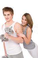 Fitness - Smiling healthy couple exercising with weights