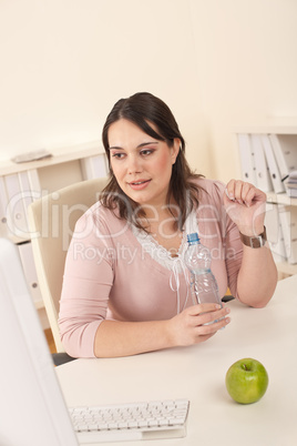 Young executive woman with bottle of water at office