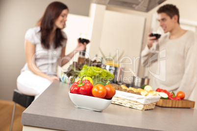 Young couple drinking red wine in kitchen