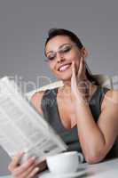Thoughtful businesswoman read newspaper at office