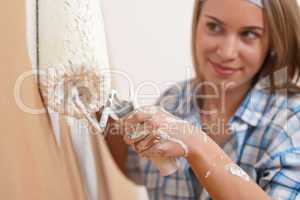 Home improvement: Young woman painting wall