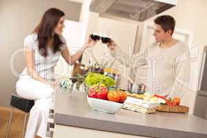 Young couple drinking red wine in kitchen