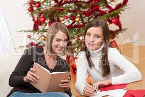 Two young women writing Christmas cards