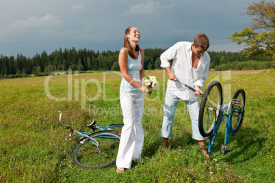 Romantic young couple with old bike in spring nature