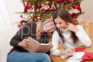Two young women writing Christmas cards