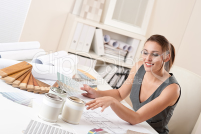 Female interior designer working at office with color swatch