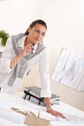 Female architect working at the office holding pen