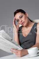 Thoughtful businesswoman read newspaper at office