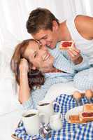Young couple having home made breakfast in bed