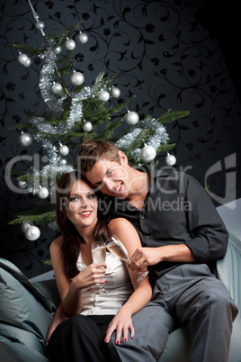 Young extravagant man and woman with champagne on Christmas
