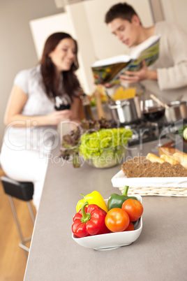 Couple in kitchen choosing recipe from cookbook