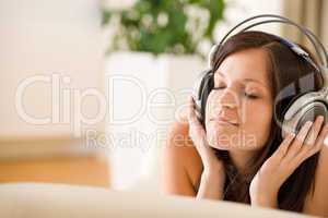 Woman with headphones listen to music in lounge