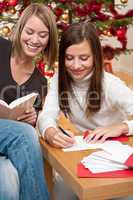 Two young women writing Christmas cards