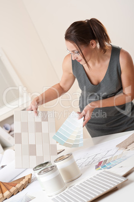 Female interior designer working at office with color swatch
