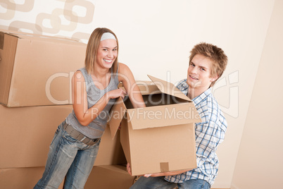 New house: Young couple moving box, unpacking