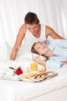 Young couple having luxury breakfast in hotel room