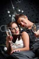 Young extravagant man and woman with champagne on Christmas