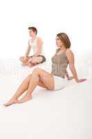Fitness - Healthy couple stretching after training on white