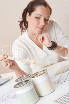 Female interior designer with cans of paint at office