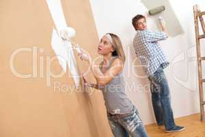 Home improvement: Young couple painting wall